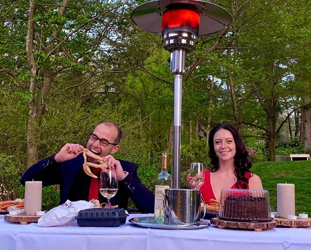 James Murray and his fiancee Melyssa Davies at an outdoors lunch table during a group Zoom conference.